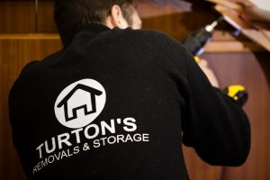 professional mover from turtons removals packing items during a house removal in the uk